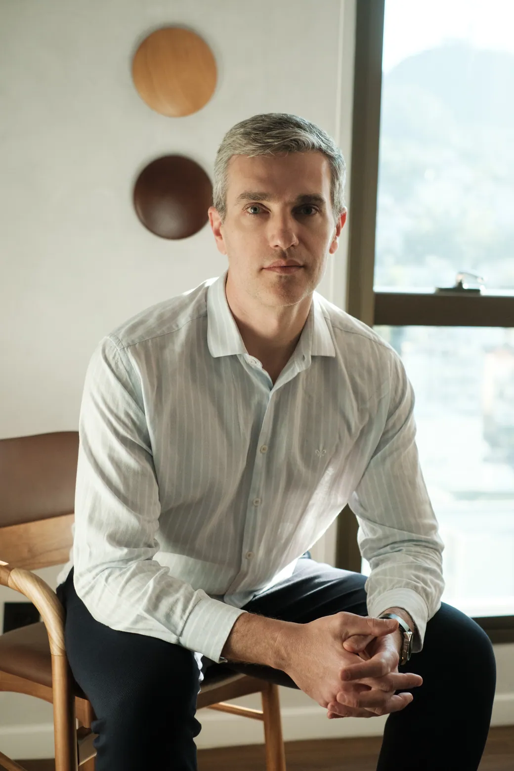 Dr. Ricardo Favaretto, otorrinolaringologista, sentado no consultório em Florianópolis